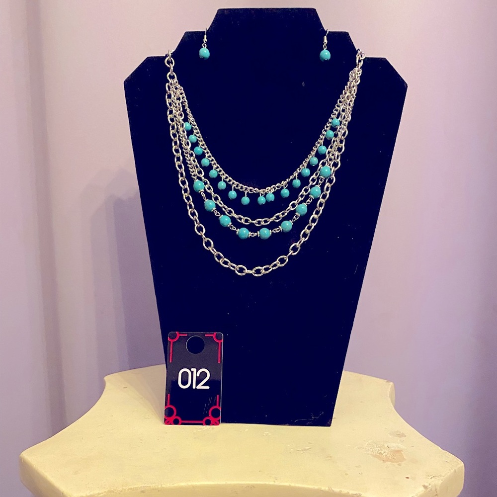 This necklace is a beautiful turquoise and silver color with four hanging layers